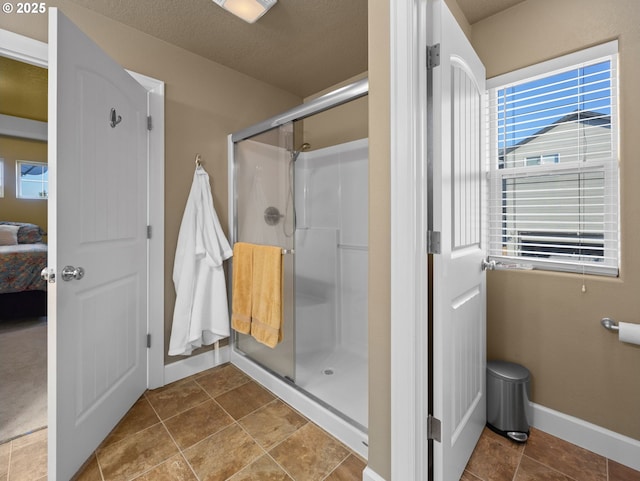 bathroom with a shower with door and a textured ceiling