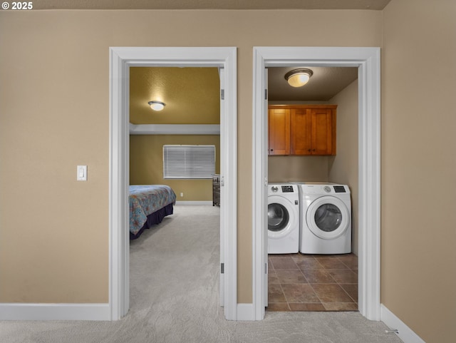 washroom with cabinets, washing machine and clothes dryer, and light carpet