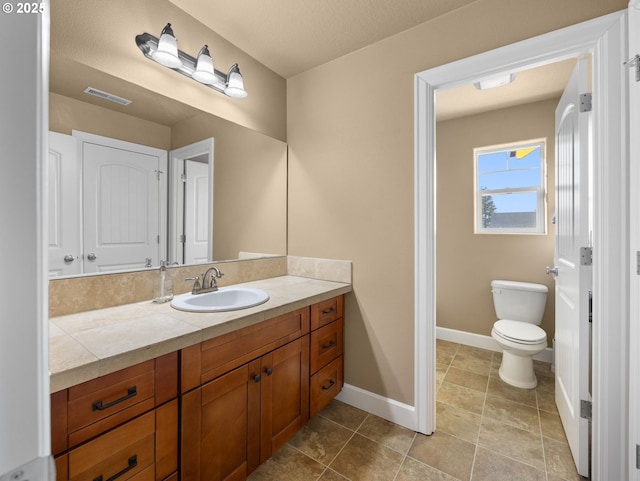 bathroom featuring vanity, tile patterned floors, and toilet