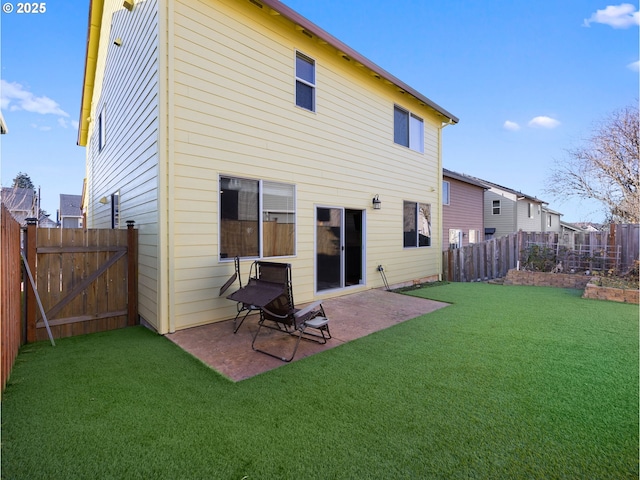 rear view of house featuring a yard and a patio