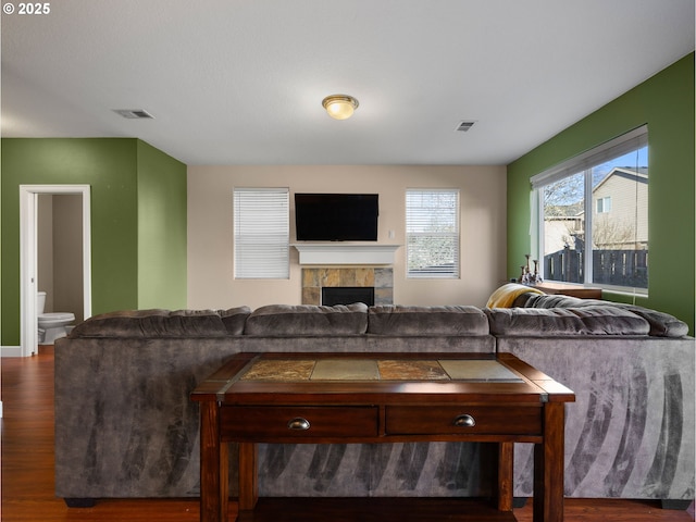 living room with dark wood-type flooring and a fireplace