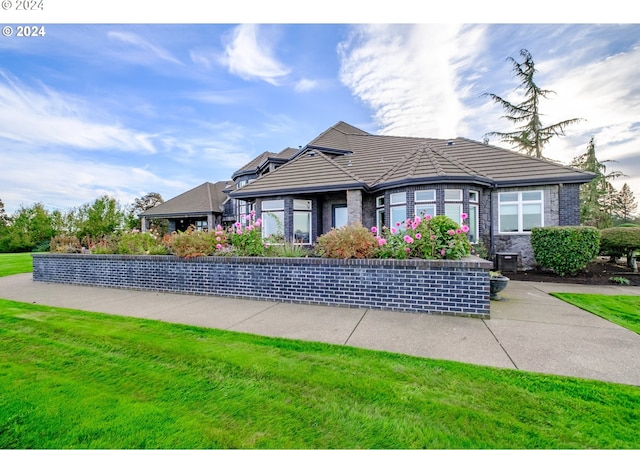 view of front facade with a front lawn and a tile roof