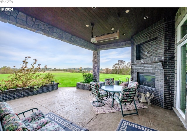 view of patio with an outdoor brick fireplace, view of golf course, and outdoor dining space