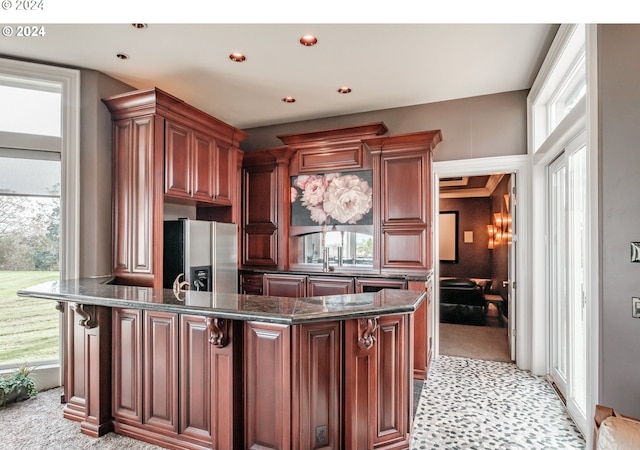 kitchen featuring stainless steel refrigerator with ice dispenser, light colored carpet, dark stone counters, and recessed lighting