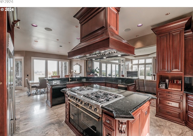 kitchen with dishwasher, range with two ovens, a center island, dark stone counters, and a peninsula