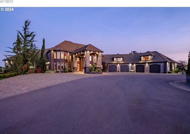 view of front of home with stone siding, driveway, and a garage