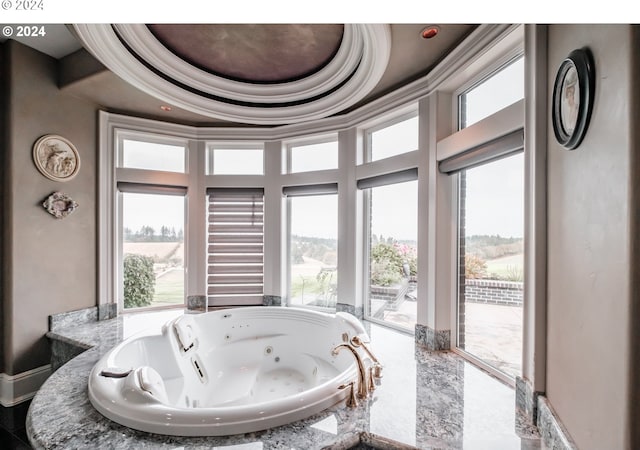 bathroom featuring a tray ceiling and a tub to relax in