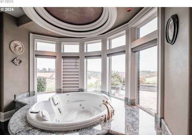 bathroom featuring a jetted tub, a sink, and a towering ceiling