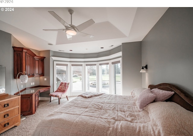 bedroom featuring light carpet, a raised ceiling, and ceiling fan