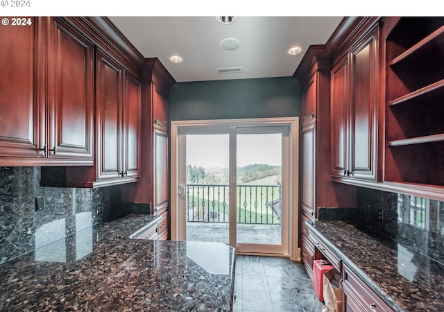 kitchen with decorative backsplash and dark stone counters