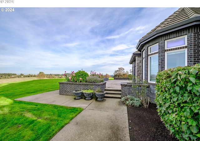 view of green lawn featuring a patio
