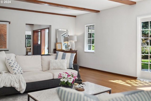 living room with light wood-type flooring, beam ceiling, and plenty of natural light