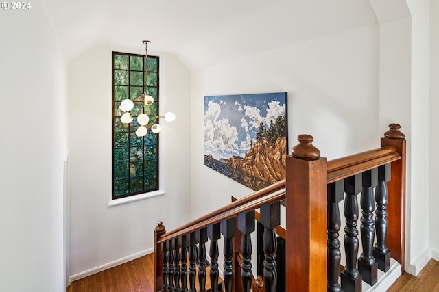 staircase featuring vaulted ceiling and wood-type flooring