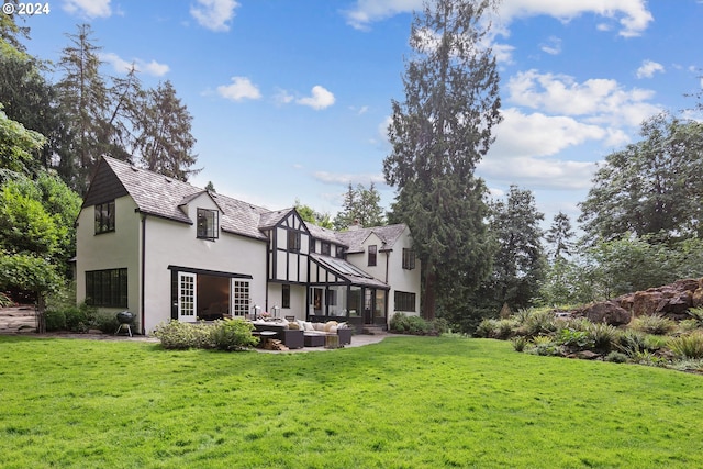 rear view of property with a yard and an outdoor living space