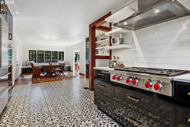 kitchen featuring stainless steel gas stovetop, tasteful backsplash, and wall chimney range hood