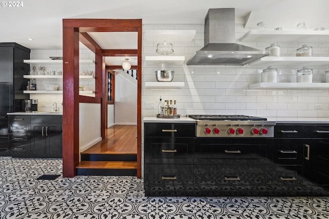 kitchen with light tile patterned floors, island range hood, backsplash, stainless steel gas cooktop, and sink