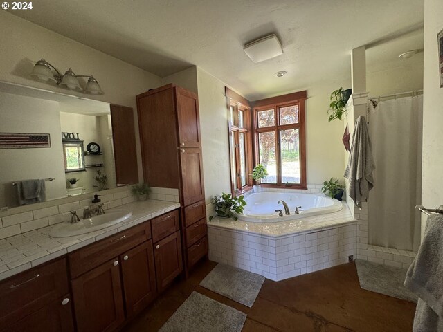 bathroom with tiled bath and vanity