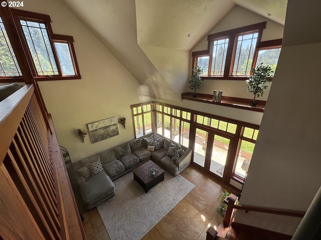 tiled living room featuring plenty of natural light and high vaulted ceiling