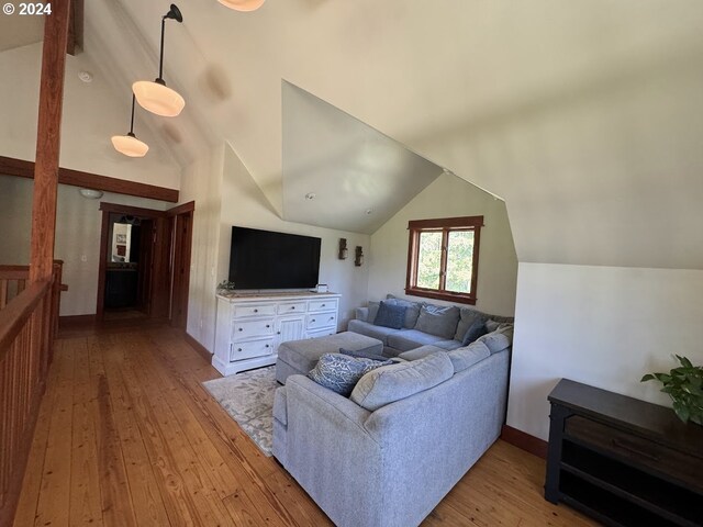 living room with vaulted ceiling with beams and light hardwood / wood-style flooring