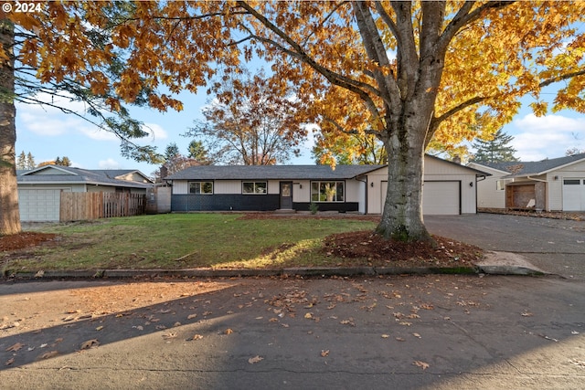 ranch-style house featuring a garage and a front yard