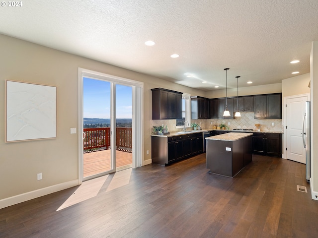 kitchen with sink, a center island, hanging light fixtures, and dark hardwood / wood-style flooring