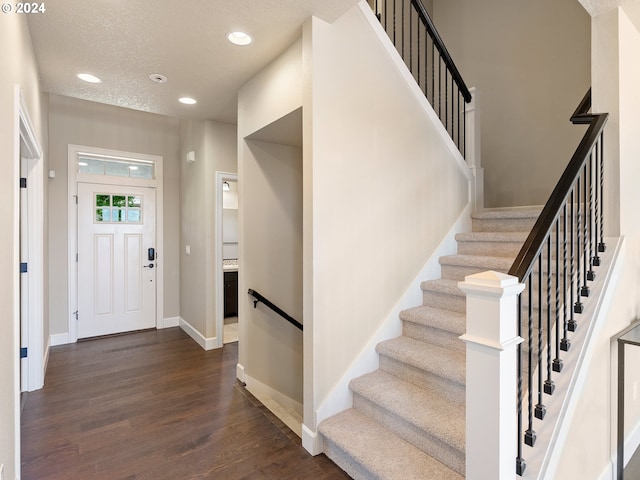 entrance foyer featuring a textured ceiling and dark hardwood / wood-style flooring