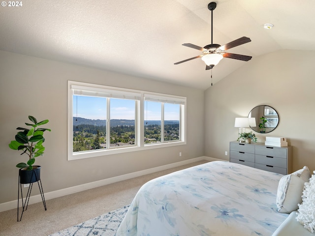 carpeted bedroom with ceiling fan, a mountain view, and vaulted ceiling