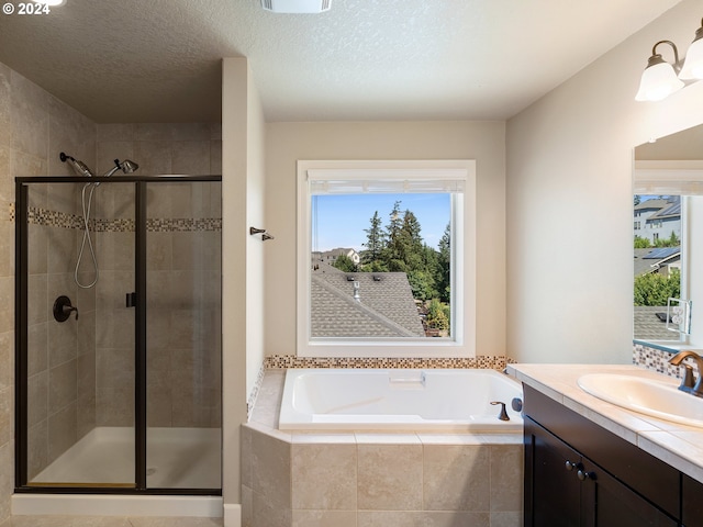 bathroom with a textured ceiling, vanity, separate shower and tub, and plenty of natural light