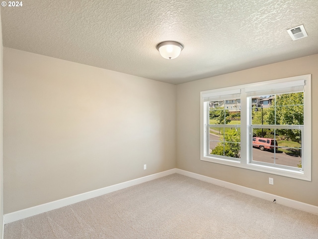 unfurnished room with carpet floors and a textured ceiling