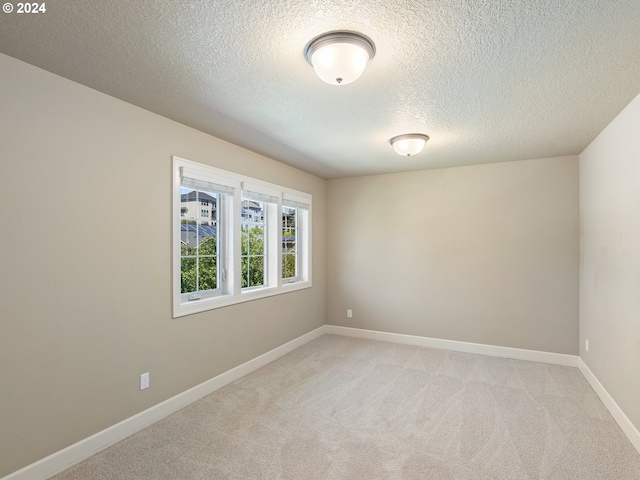 carpeted empty room with a textured ceiling