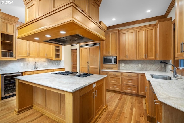 kitchen featuring wine cooler, built in appliances, a kitchen island, custom range hood, and light hardwood / wood-style flooring