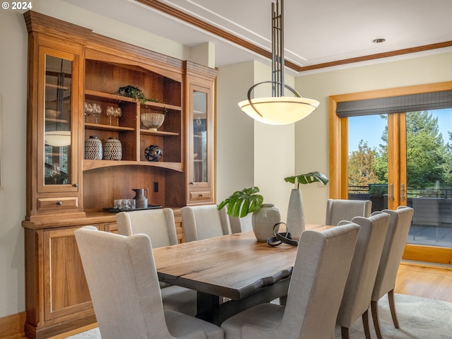 dining space featuring light hardwood / wood-style floors, ornamental molding, and french doors