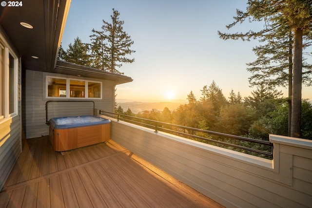 deck at dusk with a hot tub