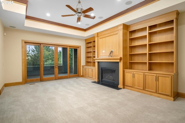 unfurnished living room featuring crown molding, ceiling fan, light colored carpet, and french doors