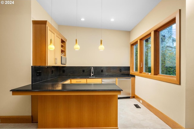 kitchen with pendant lighting, vaulted ceiling, kitchen peninsula, and tasteful backsplash