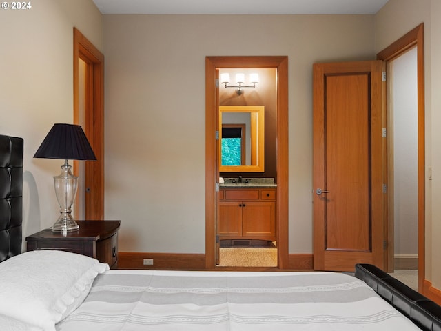 bedroom featuring connected bathroom and sink