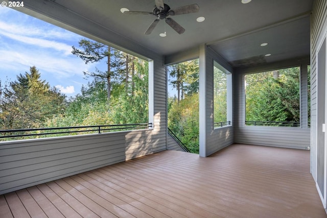 unfurnished sunroom featuring ceiling fan