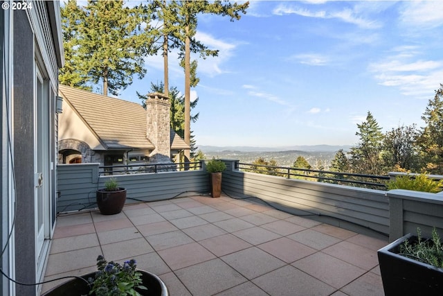 view of patio featuring a balcony and a mountain view