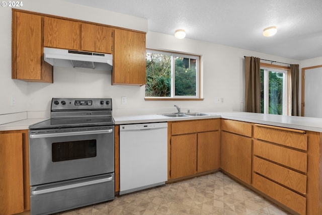 kitchen featuring dishwasher, a textured ceiling, stainless steel electric range oven, and sink