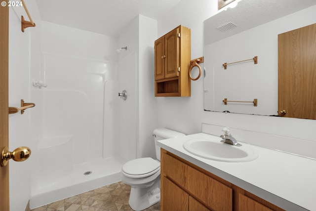 bathroom with toilet, vanity, and walk in shower