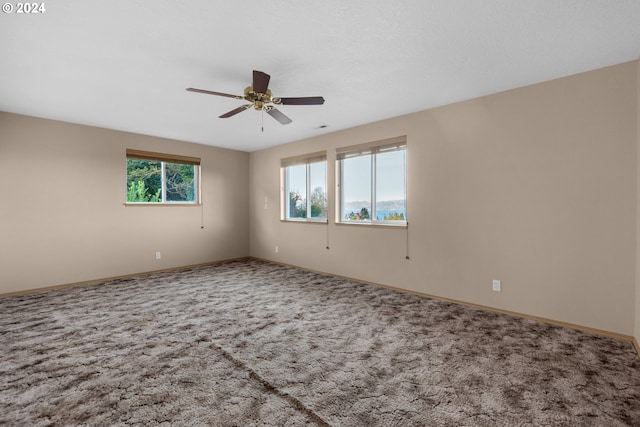 carpeted spare room featuring ceiling fan