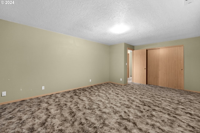 unfurnished bedroom with a textured ceiling, carpet floors, and a closet