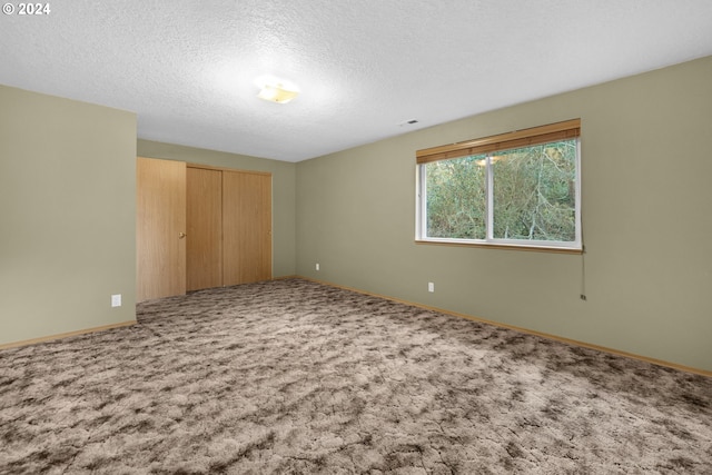 unfurnished bedroom with a closet, carpet floors, and a textured ceiling