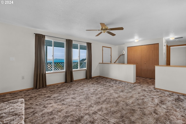 unfurnished living room featuring a textured ceiling, carpet floors, and ceiling fan