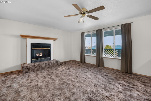 unfurnished living room with carpet flooring, a textured ceiling, and ceiling fan