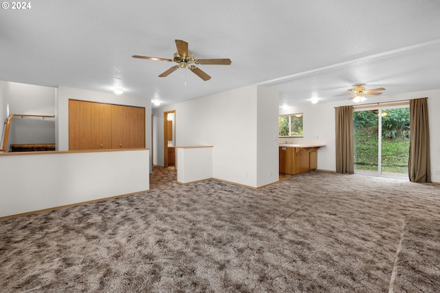 unfurnished living room with carpet and ceiling fan