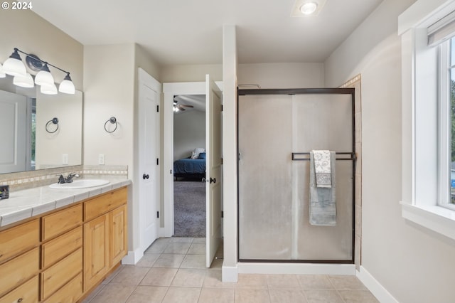 bathroom featuring vanity, a healthy amount of sunlight, a shower with shower door, and ceiling fan