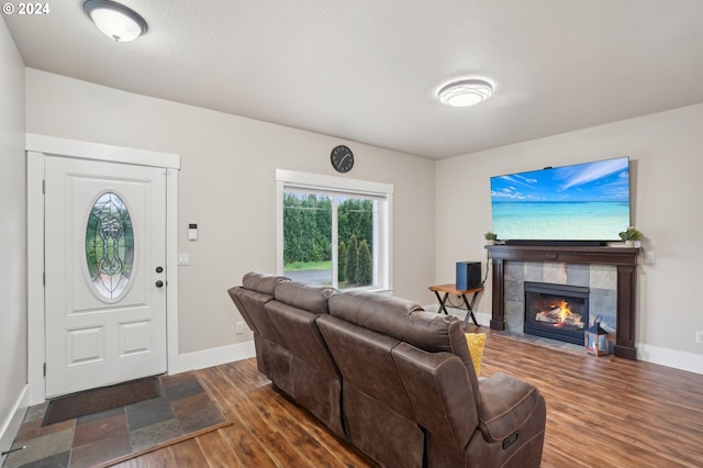 living room with a tile fireplace and dark hardwood / wood-style floors