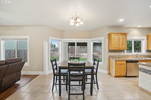 tiled dining space with an inviting chandelier, sink, and a wealth of natural light