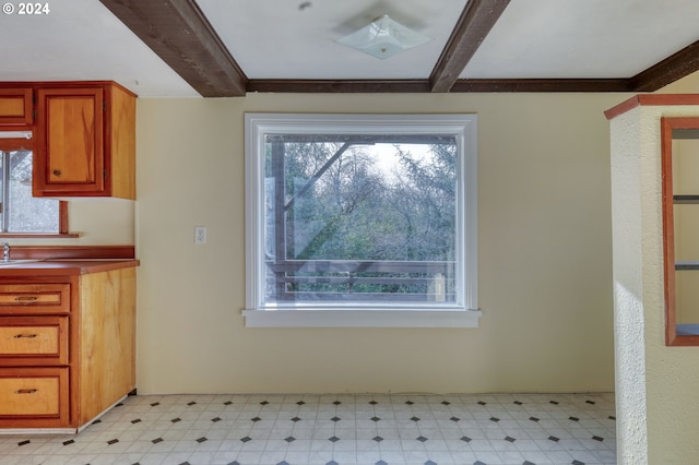 interior space with crown molding, plenty of natural light, and beamed ceiling